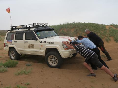 越野车亦陷进沙中，辛苦了摄制队和导演推车。