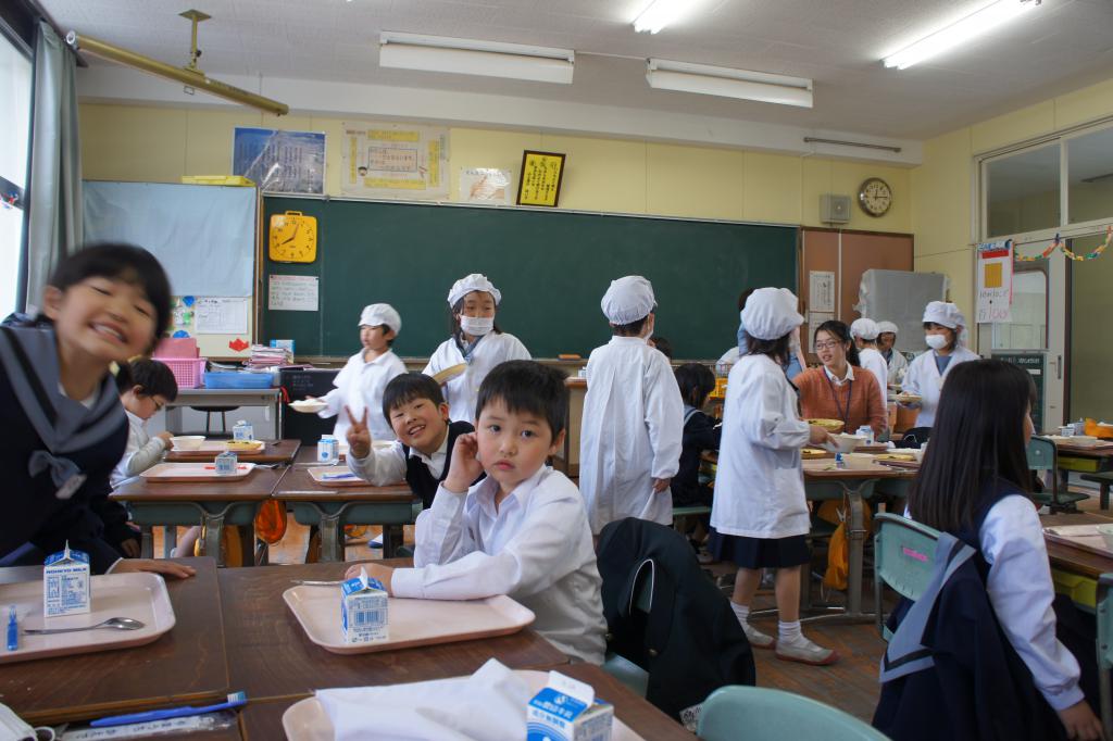 再到小學參觀 午飯時間－負責派餐的學生穿著白色頭套、口罩和衣物為大家分配午餐